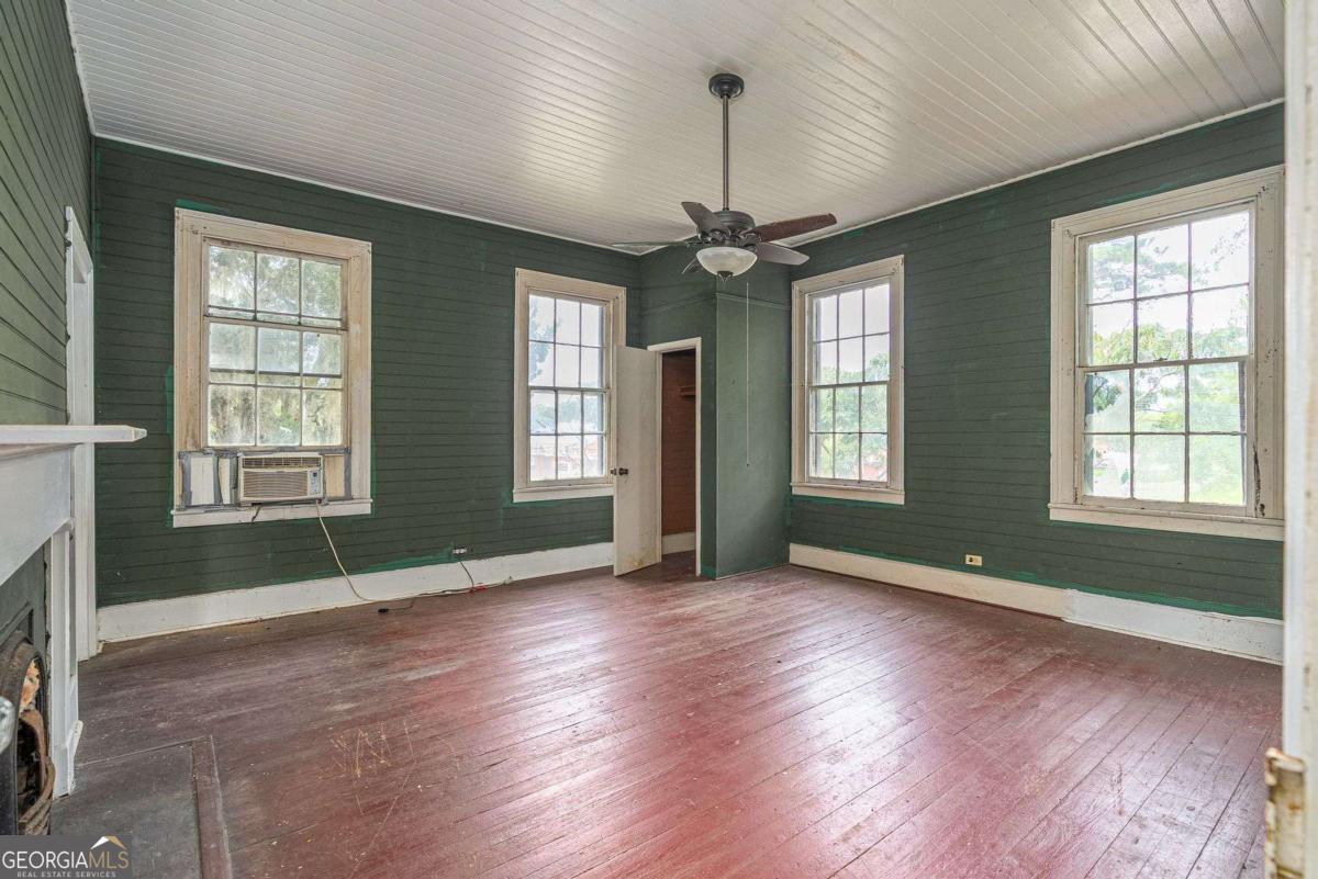 602 Magnolia Street Guyton, GA 31312 - Photo 27 of 34 a view of an empty room with wooden floor and a window
