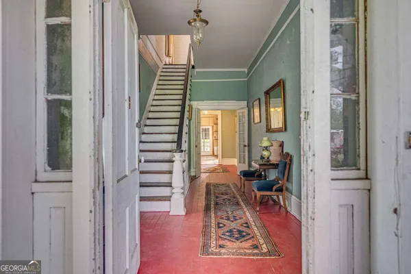 a view of a hallway with wooden floor and windows