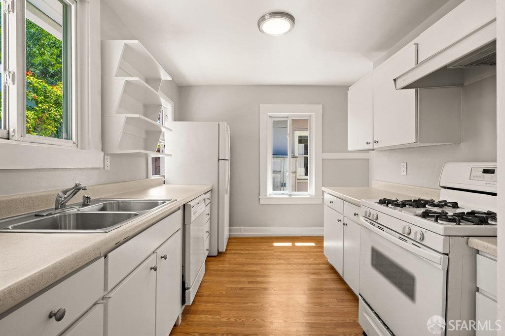 3111 Wheeler Street Berkeley, CA 94705 - Photo 17 of 44 a kitchen with granite countertop a sink stainless steel appliances white cabinets and a window