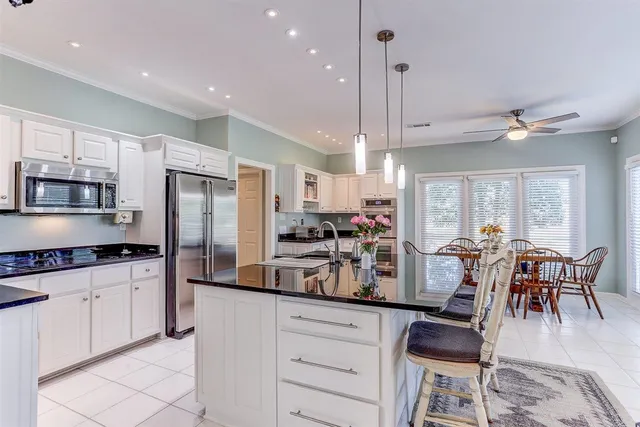a kitchen with refrigerator cabinets dining table and chairs