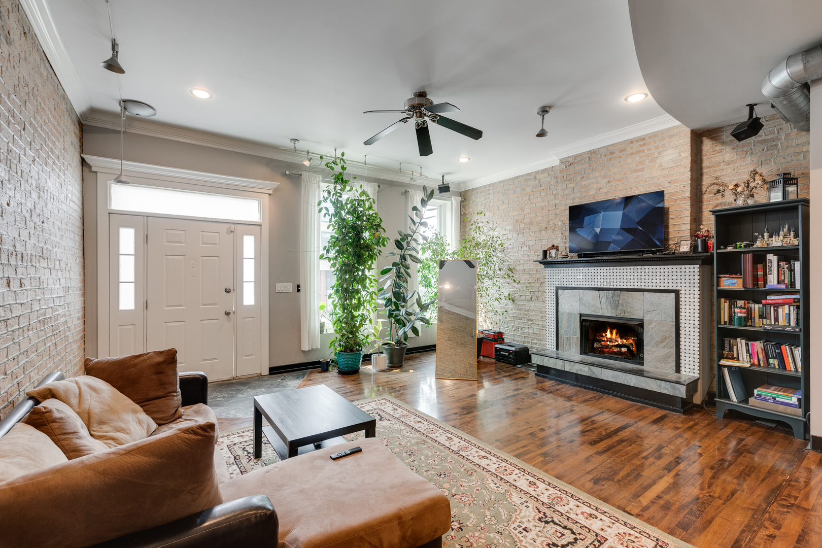 1005 South Racine Avenue Chicago, IL 60607 - Photo 2 of 16 a living room with furniture a fireplace and a flat screen tv