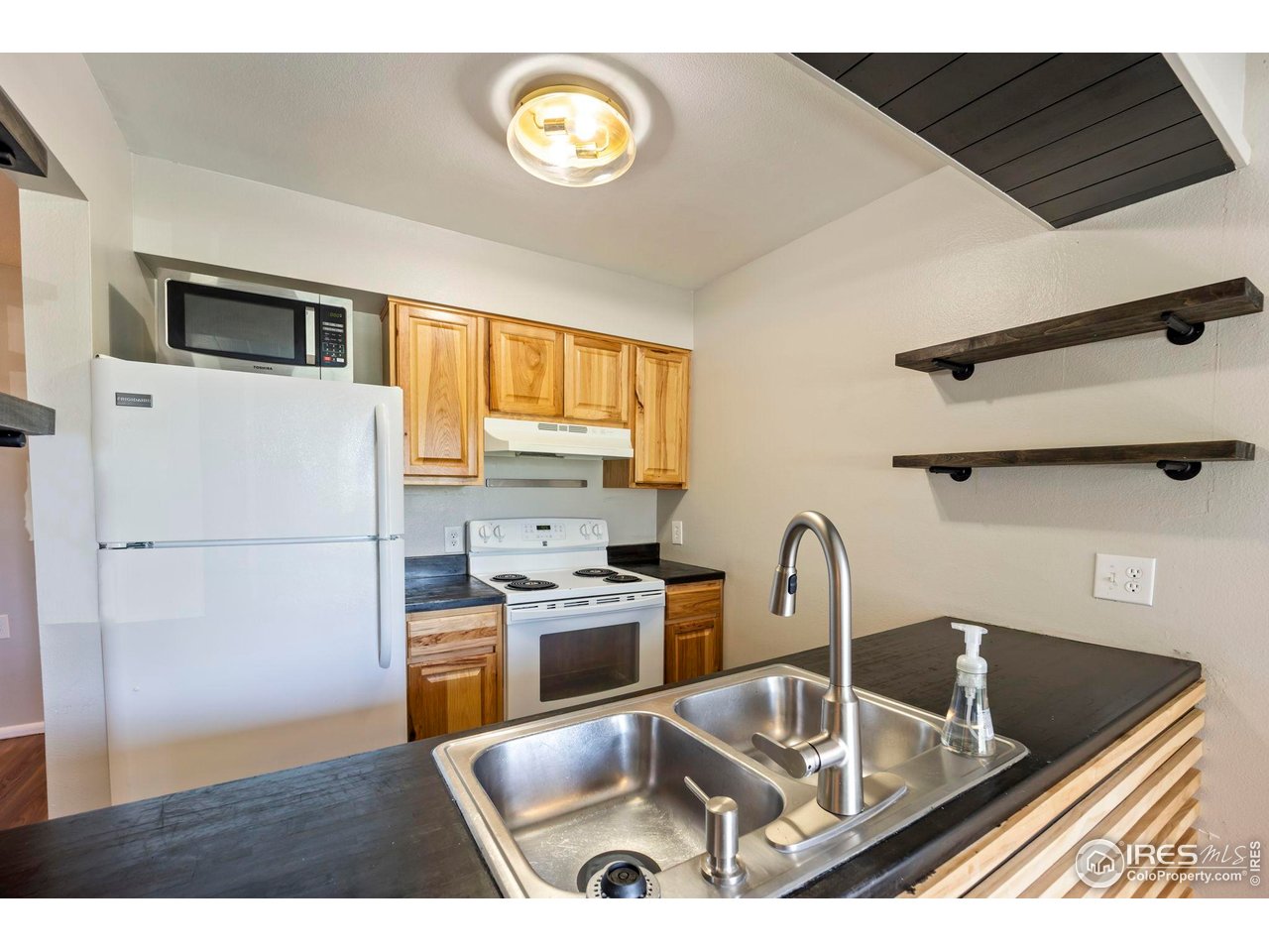3431 Stover Street, Unit 513 Fort Collins, CO 80525 - Photo 12 of 28 a kitchen with stainless steel appliances granite countertop a sink a stove and a refrigerator