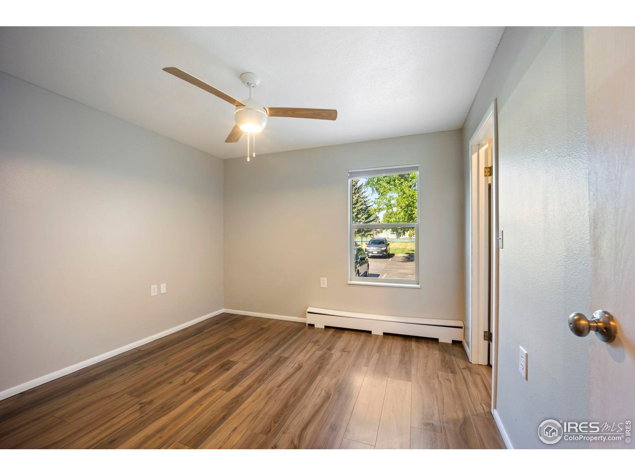 3431 Stover Street, Unit 513 Fort Collins, CO 80525 - Photo 17 of 28 a view of an empty room with wooden floor and a window
