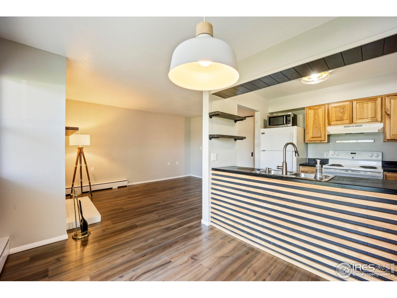 3431 Stover Street, Unit 513 Fort Collins, CO 80525 - Photo 2 of 28 a view of a kitchen with kitchen island a sink wooden floor and a chandelier