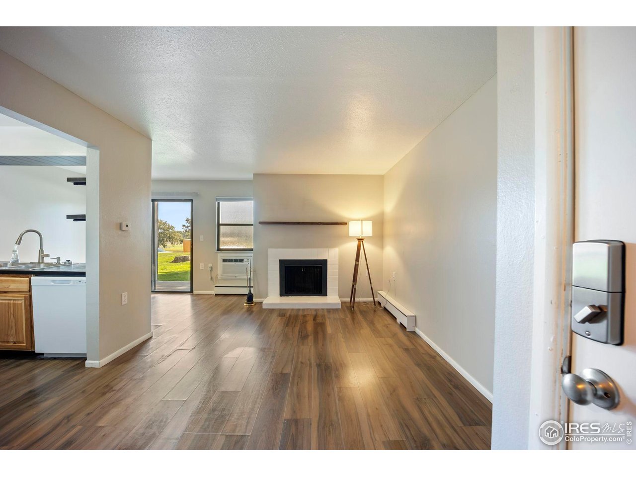 3431 Stover Street, Unit 513 Fort Collins, CO 80525 - Photo 6 of 28 a view of a livingroom with wooden floor and a fireplace