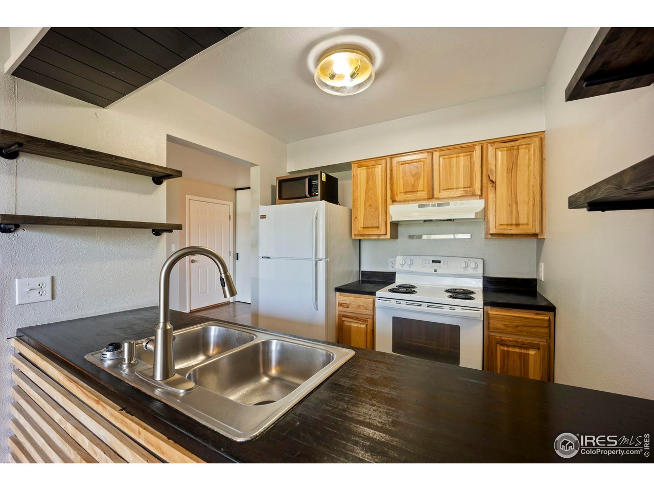 3431 Stover Street, Unit 513 Fort Collins, CO 80525 - Photo 10 of 28 a kitchen with stainless steel appliances granite countertop a sink a stove and a refrigerator