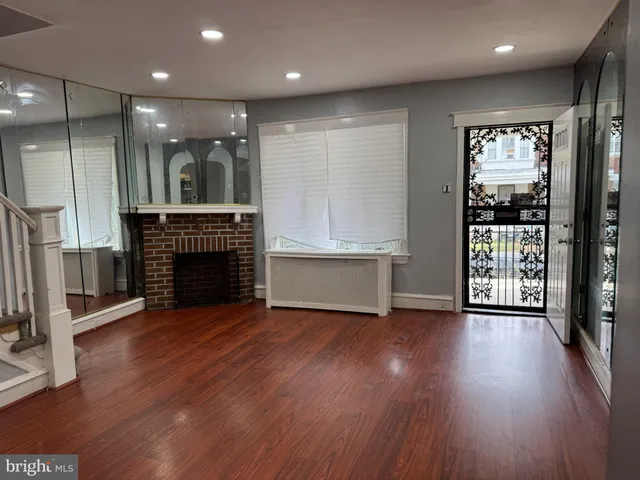 a view of a livingroom with wooden floor and a fireplace