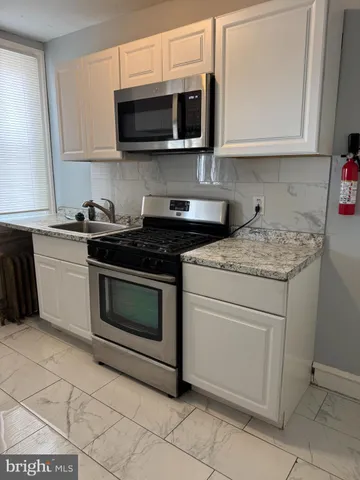 a kitchen with stainless steel appliances granite countertop a stove microwave and sink