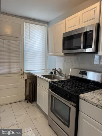 a kitchen with stainless steel appliances granite countertop a stove and a microwave