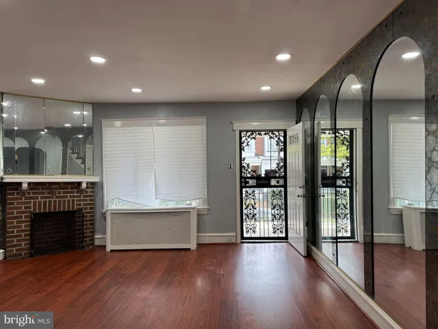 an empty room with wooden floor and fireplace