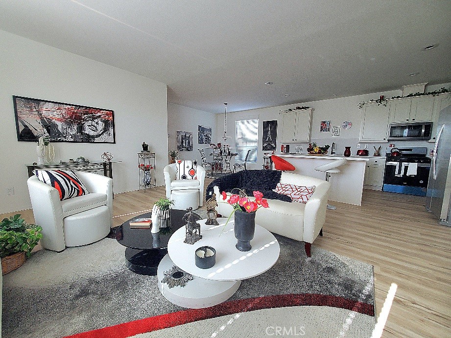 21621 Sandia Road, Unit 150 Apple Valley, CA 92308 - Photo 1 of 45 a living room with furniture and a dining table with wooden floor
