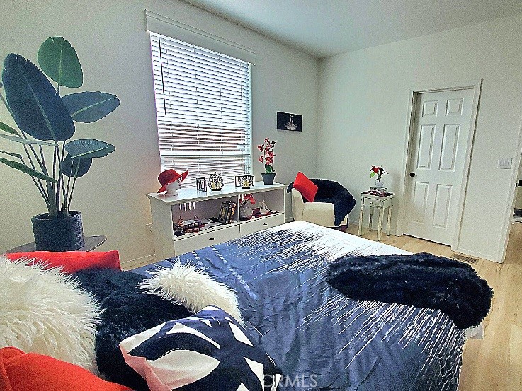 21621 Sandia Road, Unit 150 Apple Valley, CA 92308 - Photo 19 of 45 a bedroom with a bed and a chandelier