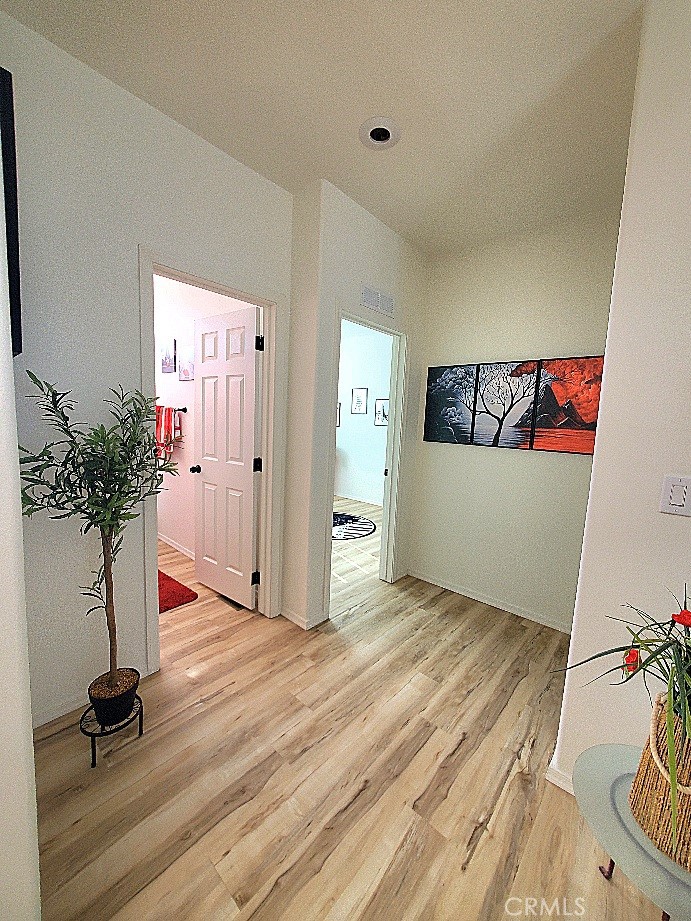 21621 Sandia Road, Unit 150 Apple Valley, CA 92308 - Photo 25 of 45 a view of a hallway with wooden floor and a potted plant
