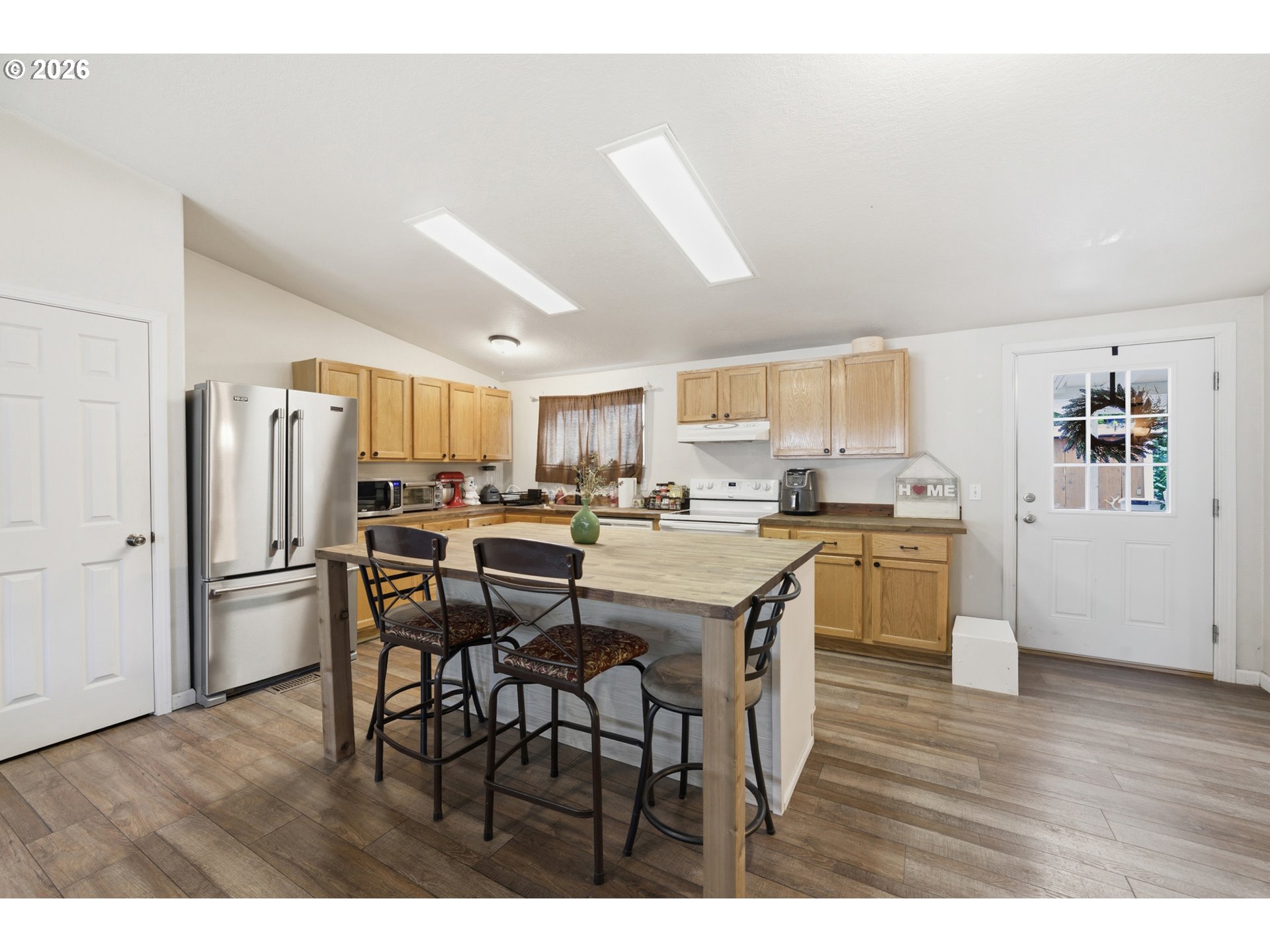 655 Northeast Burnett Road, Unit 91 McMinnville, OR 97128 - Photo 15 of 27 a kitchen with stainless steel appliances granite countertop a refrigerator a sink dishwasher and white cabinets with wooden floor