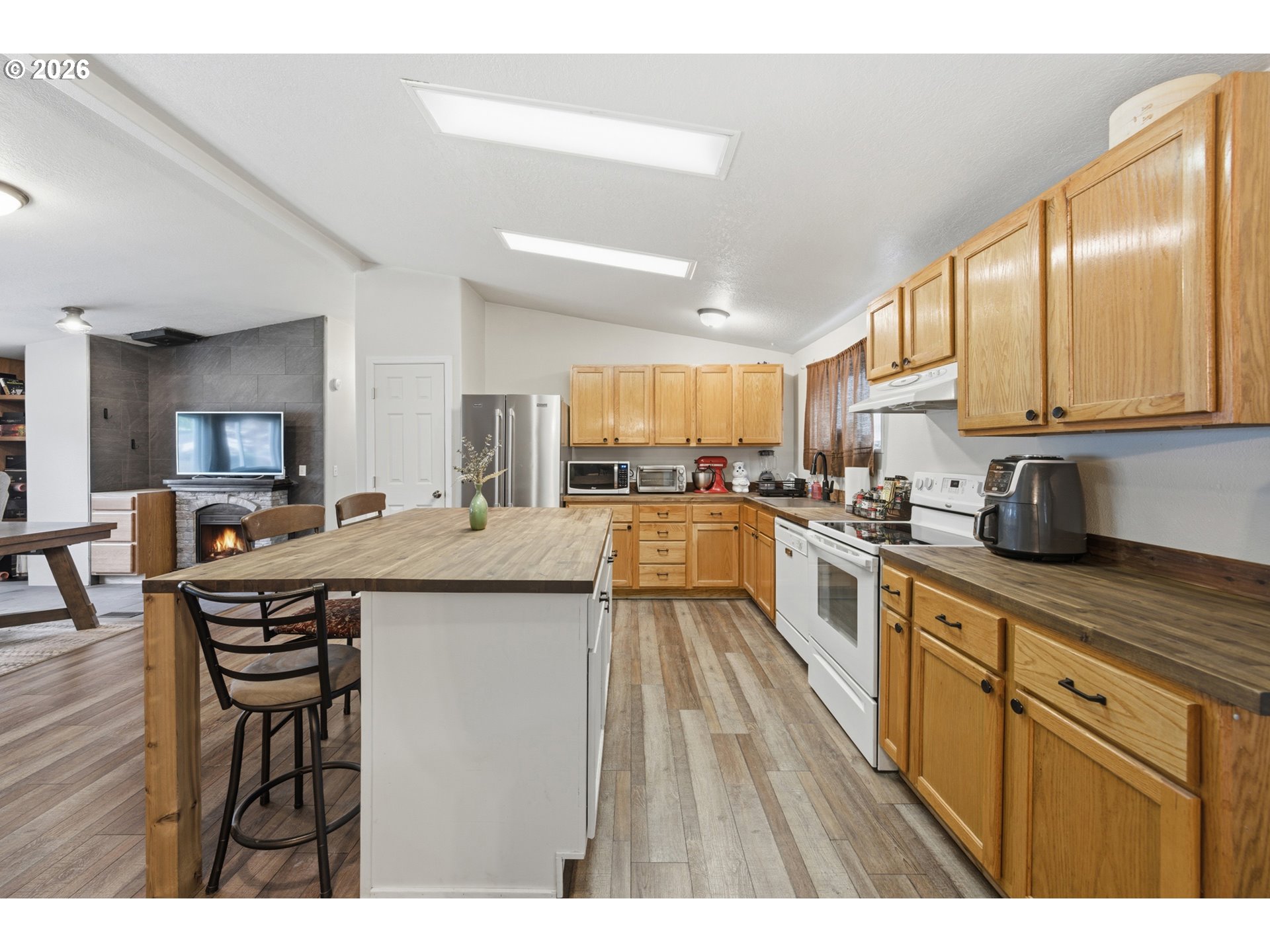 655 Northeast Burnett Road, Unit 91 McMinnville, OR 97128 - Photo 17 of 27 a kitchen with stainless steel appliances granite countertop wooden cabinets a sink a stove a dining table and chairs