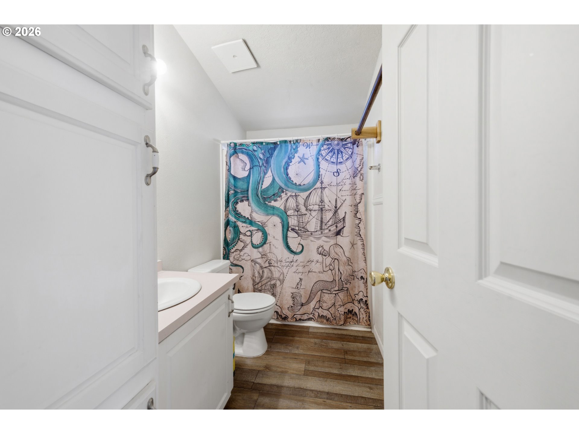 655 Northeast Burnett Road, Unit 91 McMinnville, OR 97128 - Photo 24 of 27 a bathroom with a toilet and a shower curtain