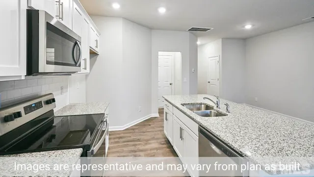 a kitchen with a sink stove and microwave