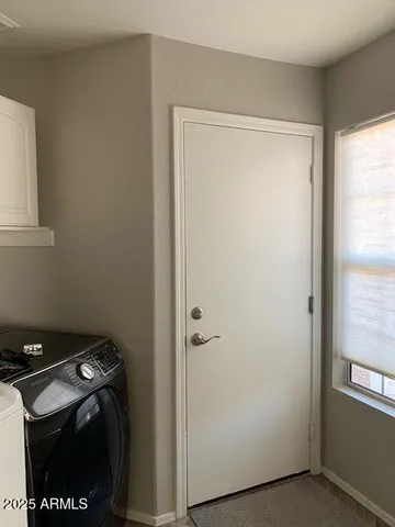 a view of an empty room with wooden floor and a ceiling fan