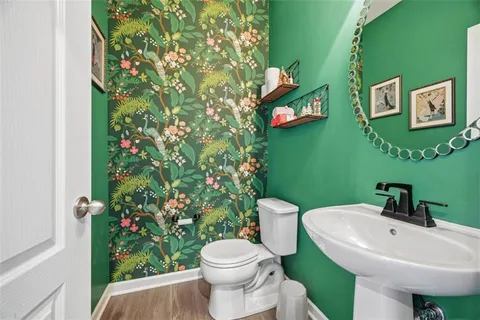 a kitchen with stainless steel appliances kitchen island granite countertop a stove top oven a sink a dining table and chairs with wooden floor