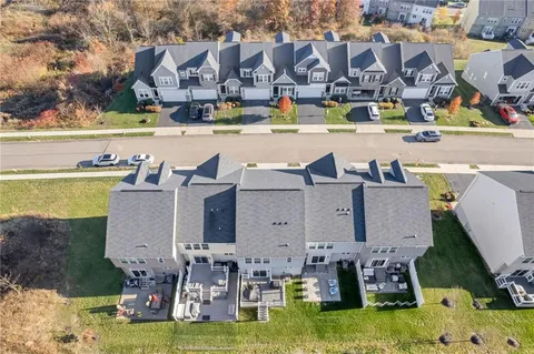 an aerial view of residential houses with outdoor space and ocean view
