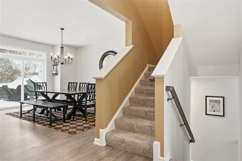 a kitchen with a table chairs a stove a dining table and a chandelier