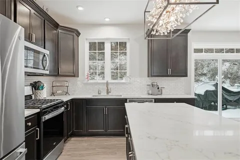 a kitchen with a center island appliances and cabinets