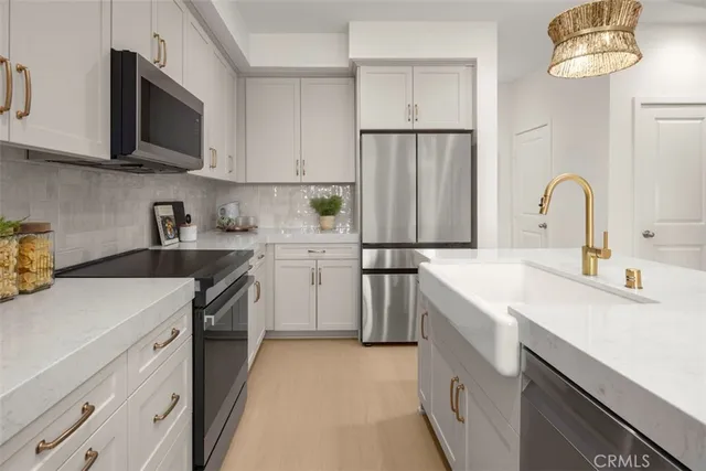 a kitchen with a sink dishwasher a stove and a refrigerator with wooden floor