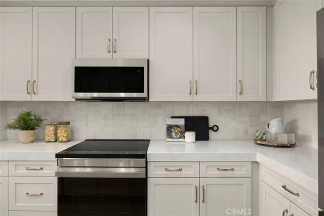 a kitchen with appliances a microwave and cabinets