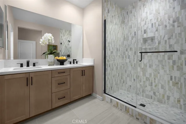 a bathroom with a double vanity sink a mirror and shower