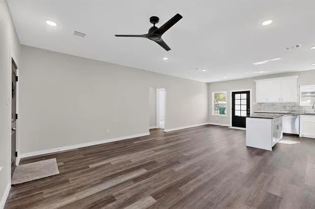a view of empty room with wooden floor and window