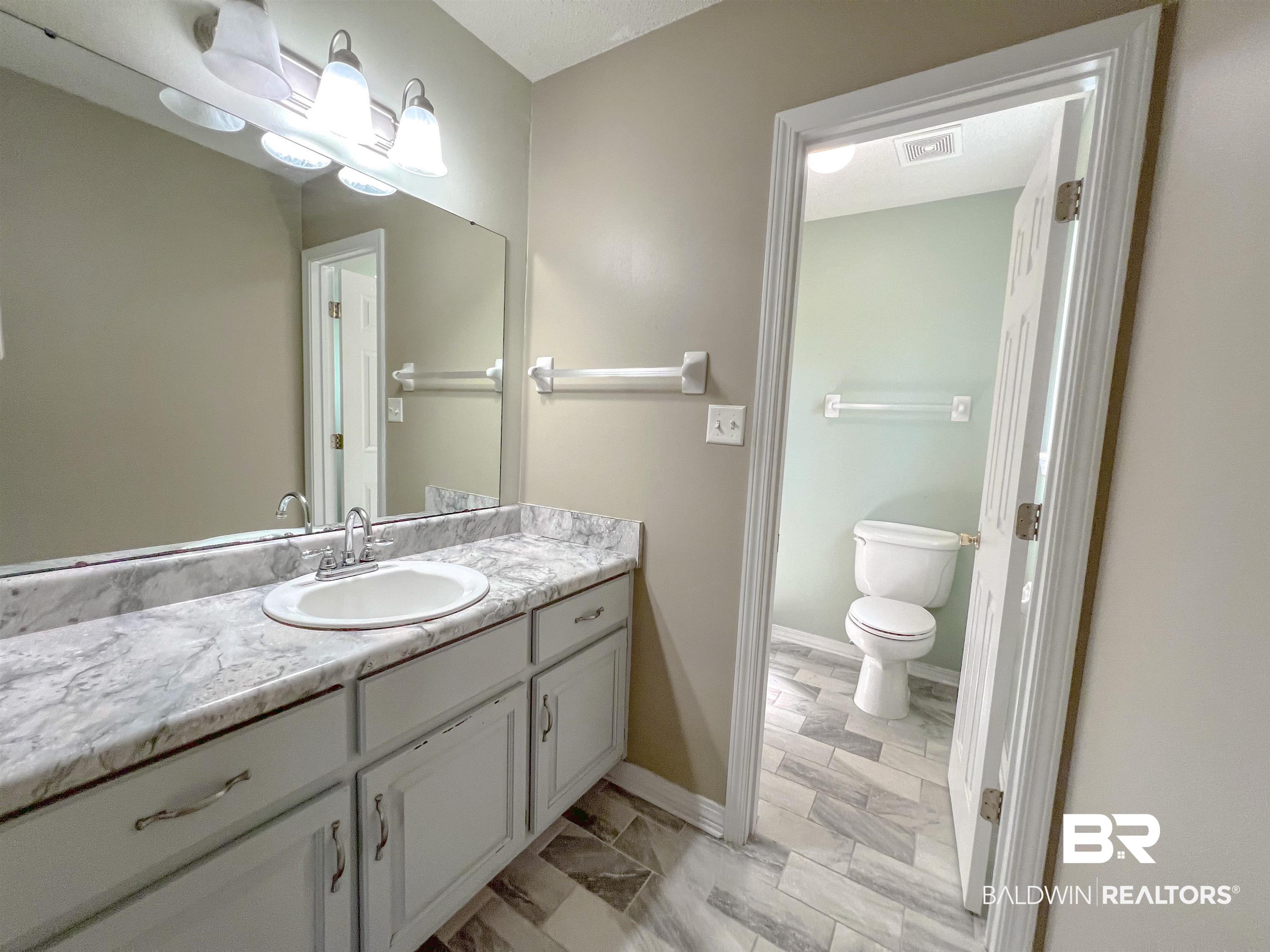 1200 South Juniper Street Foley, AL 36535 - Photo 16 of 23 Bathroom featuring tile patterned floors, vanity, and toilet