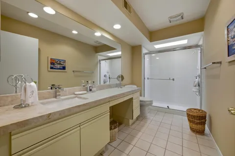 a bathroom with a granite countertop sink a toilet and a mirror