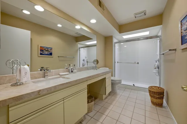 a bathroom with a granite countertop sink a toilet and a mirror