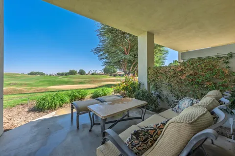 a view of a patio with furniture and garden