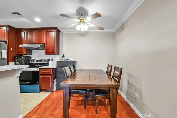 a kitchen with granite countertop stainless steel appliances a stove top oven a sink a counter space and dining table