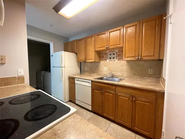 a kitchen with a refrigerator and a sink