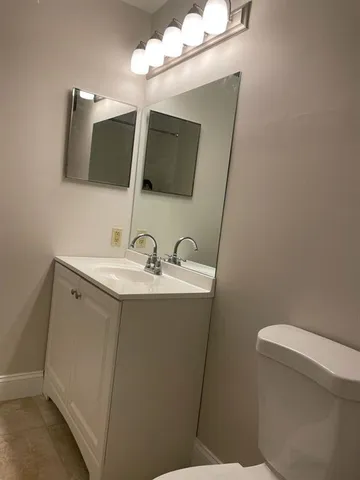 a bathroom with a sink mirror and toilet