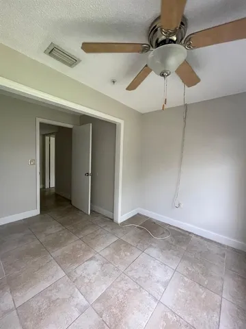 a view of an empty room with a ceiling fan