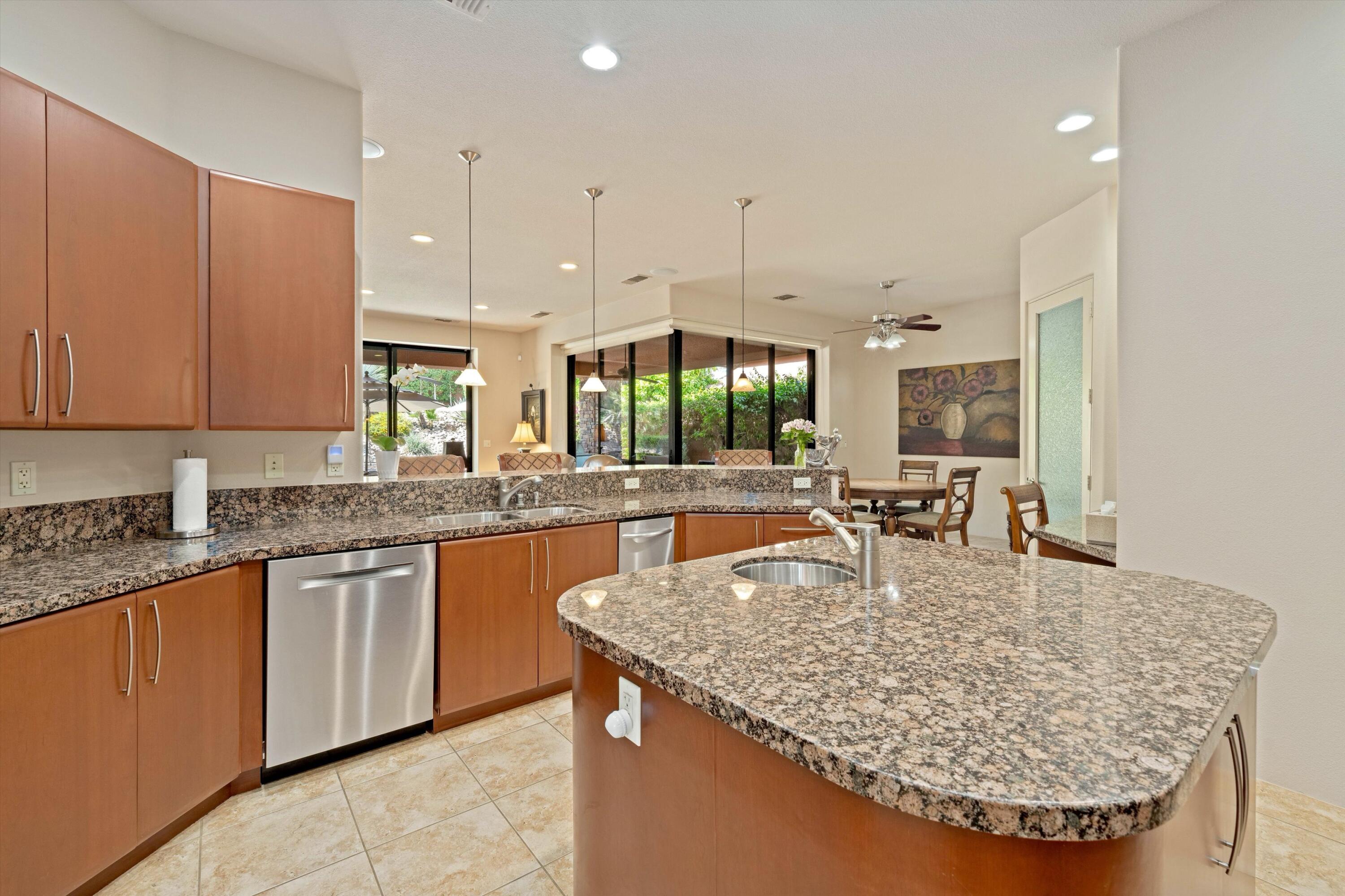 79625 Vía Sin Cuidado La Quinta, CA 92253 - Photo 31 of 52 a kitchen with granite countertop kitchen island sink stove and cabinets