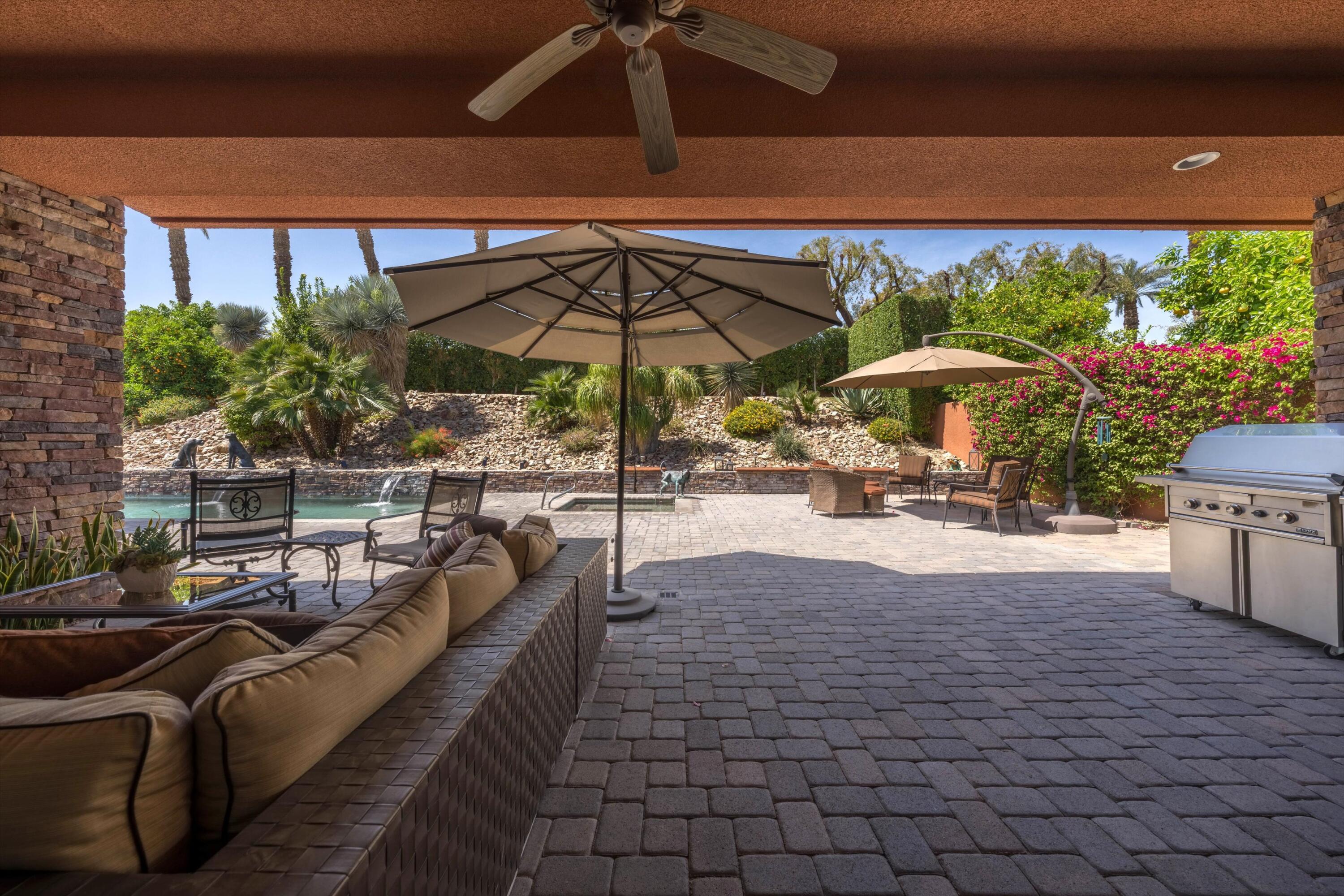 79625 Vía Sin Cuidado La Quinta, CA 92253 - Photo 8 of 52 a view of a patio with a table and chairs under an umbrella