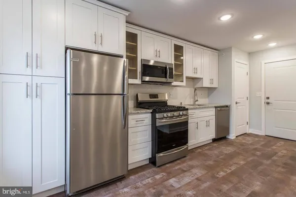 a kitchen with stainless steel appliances granite countertop a refrigerator stove a sink and a microwave
