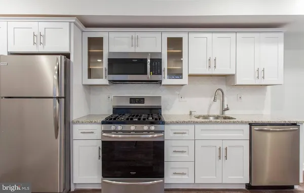 a kitchen with cabinets stainless steel appliances a sink and a counter space