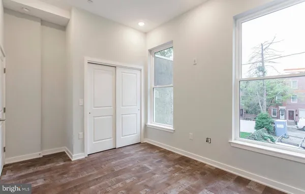 an empty room with windows and closet