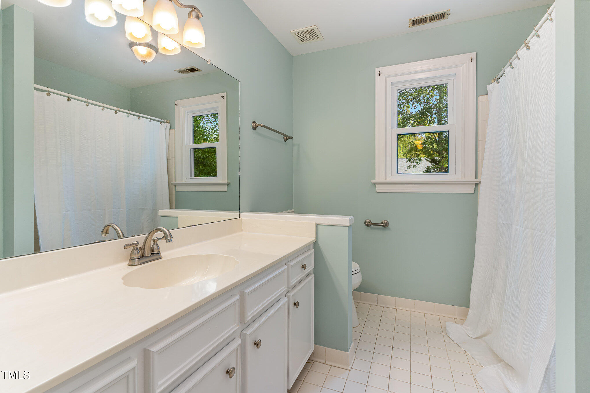 3008 Dunkirk Drive Raleigh, NC 27613 - Photo 19 of 33 a bathroom with a sink a vanity and a mirror