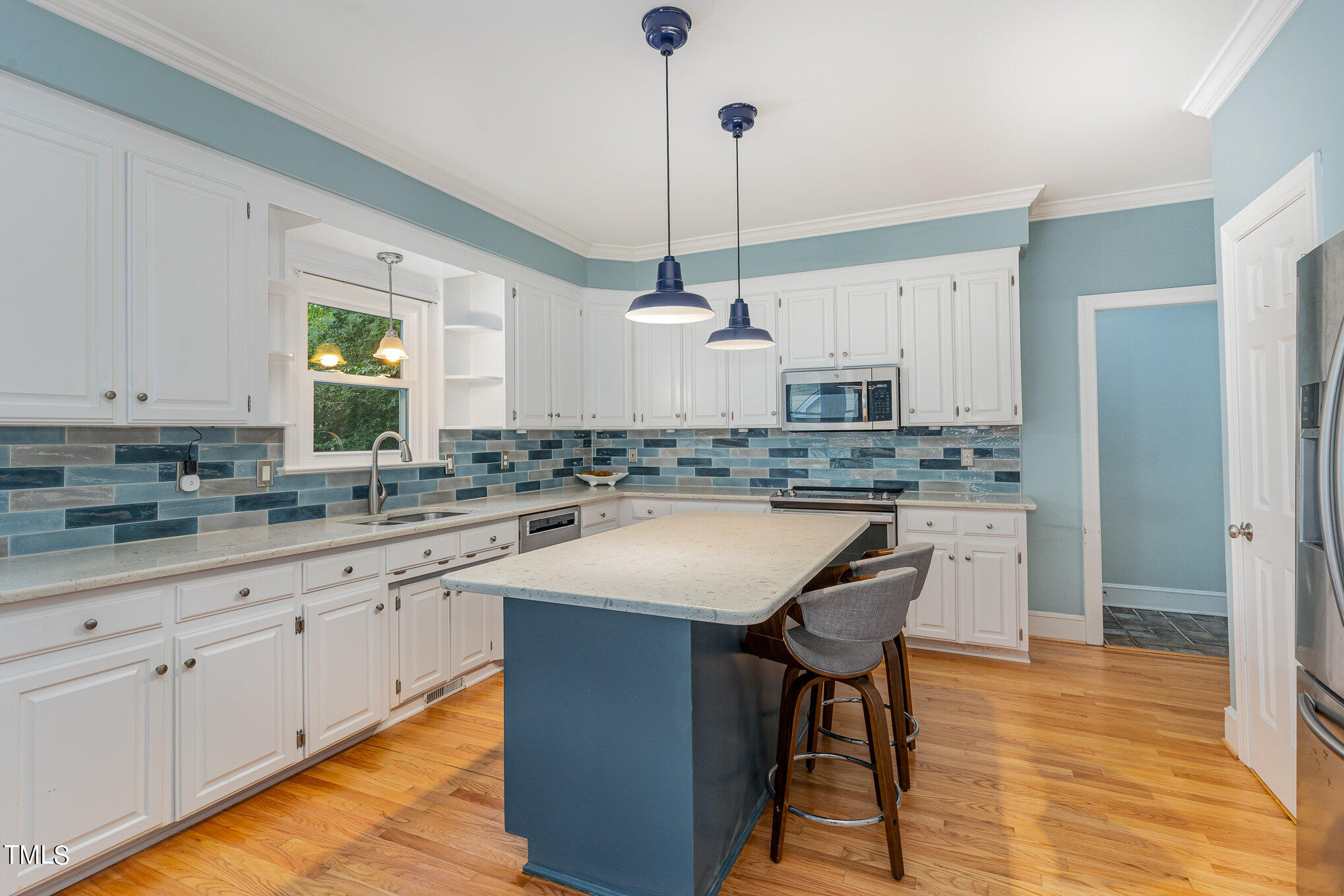 3008 Dunkirk Drive Raleigh, NC 27613 - Photo 5 of 33 a kitchen with kitchen island granite countertop a sink a center island and cabinets