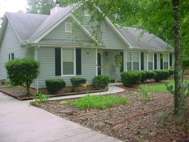 a front view of a house with a yard and potted plants