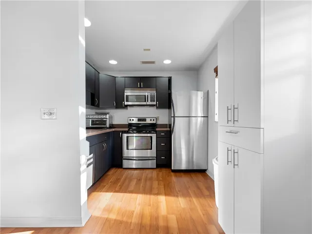 a kitchen with stainless steel appliances a refrigerator and a stove top oven