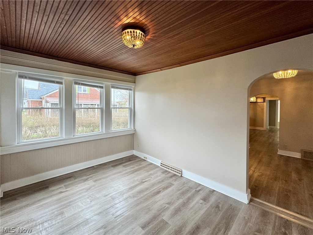 Spare room with ornamental molding, hardwood / wood-style flooring, and wood ceiling
