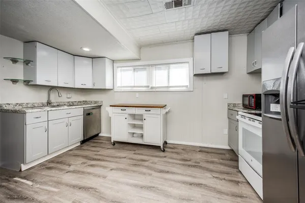 a kitchen with a refrigerator stove top oven and cabinets