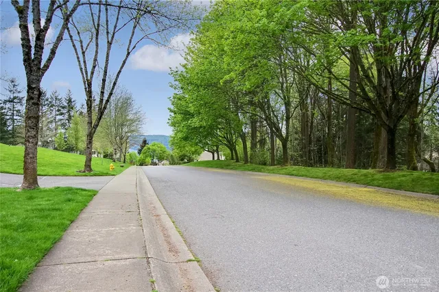a front view of a house with a yard and potted plants